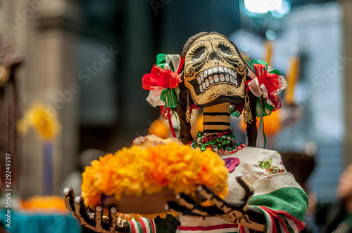 Foto catrina sonriente ene l dia de muertos con trenzas multicolores y una bandeja co