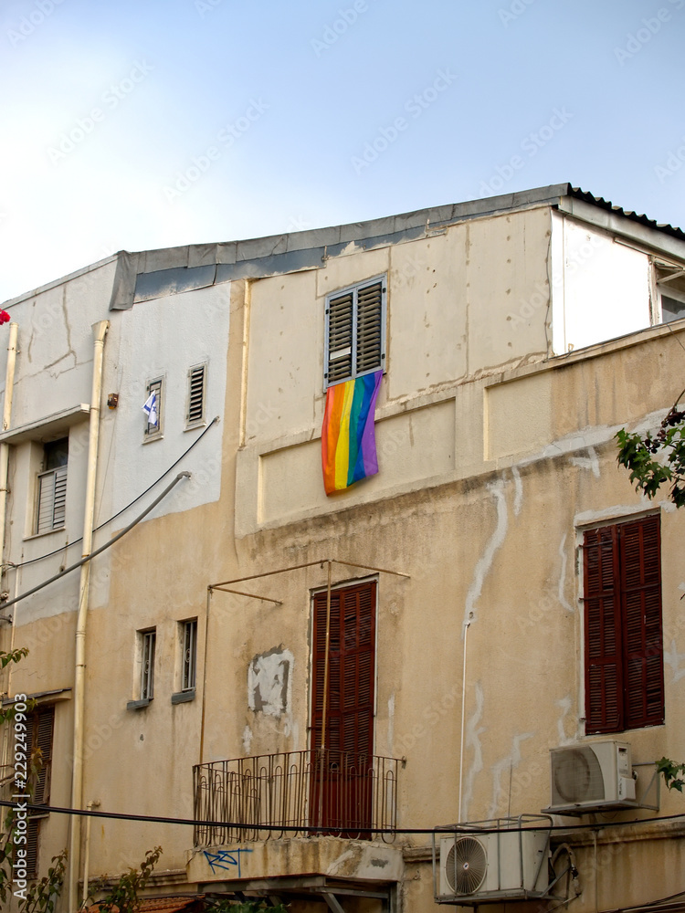 The iridescent flag hangs on a house facade. Tel Aviv, Israel