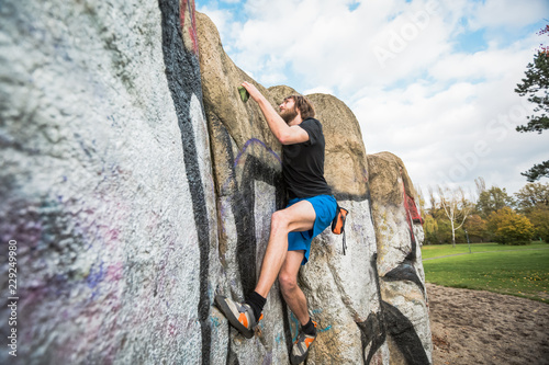Sticker Sport - bouldering: a young man is climbing on a hil