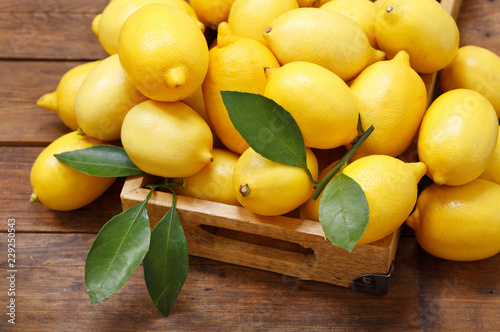 fresh lemons in a wooden box, top view