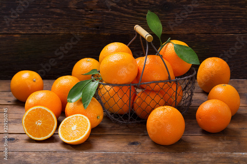 fresh orange fruits in a basket on wooden table