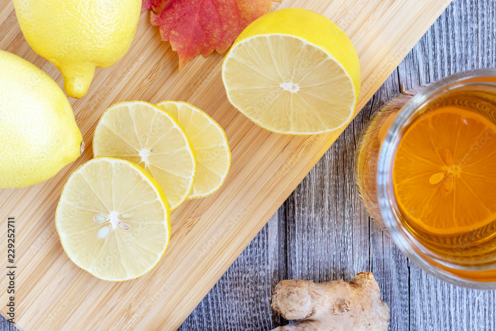 Ginger tea with lemon on a wooden table and pieces of diced lemon Ginger tea with lemon on a wooden table and pieces of diced lemon