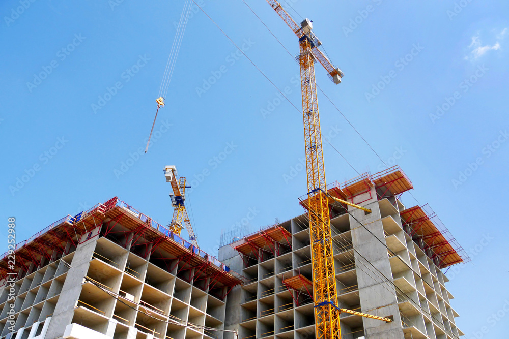 Construction site background.Two self-erection cranes near building.