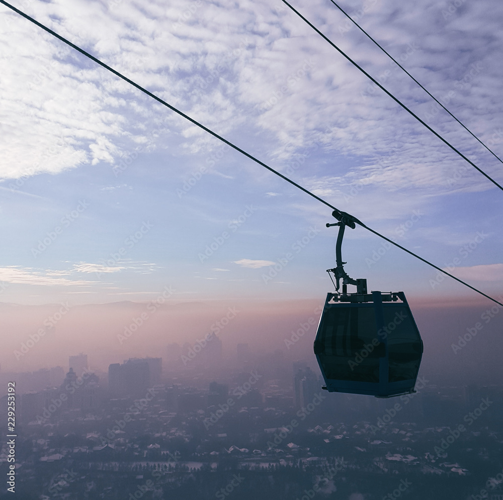 Cable car on the line during sunset in the fog