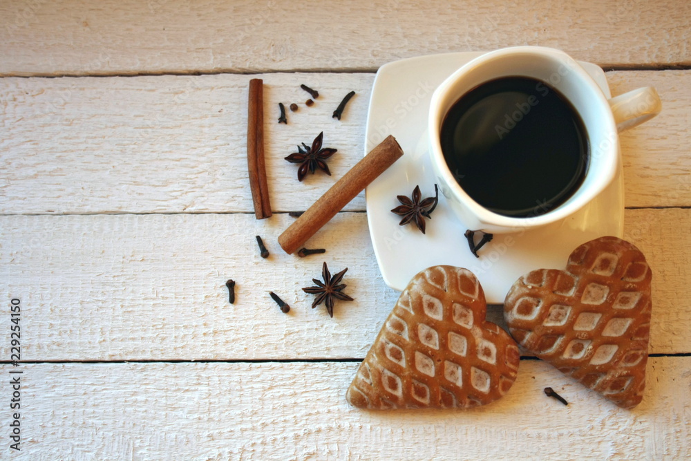 Coffee, gingerbread in the shape of hearts, anise and cinnamon on a white background Coffee, gingerbread in the shape of hearts, anise and cinnamon on a white background