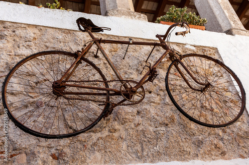 old rusty bicycle hanging on a white wall