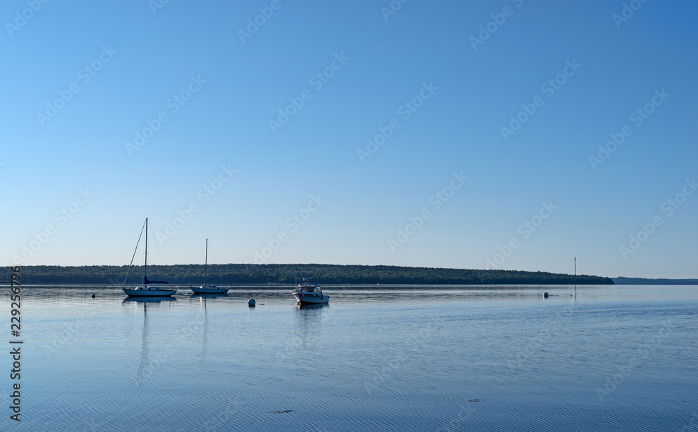 Early morning wide view of boats moored on Penobscot Bay at Searsport, Maine with Sears Island in the background.