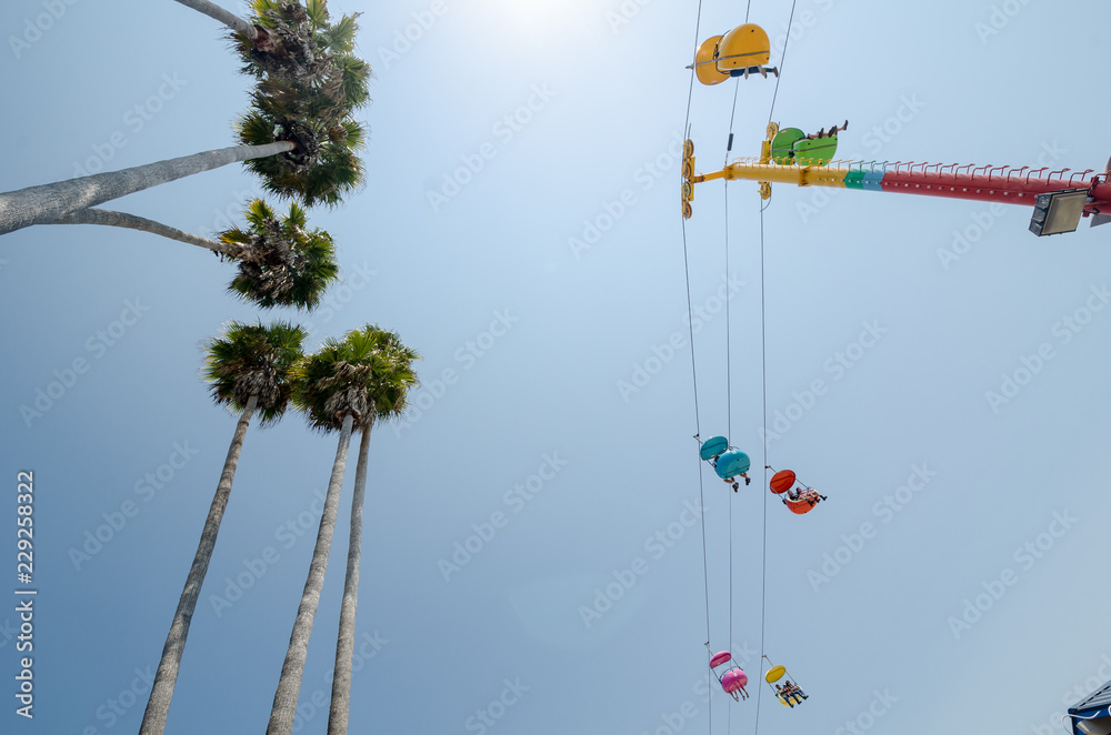 Skyride on the Santa Cruz boardwalk, looking up against the sky. Palm trees in photo Skyride on the Santa Cruz boardwalk, looking up against the sky. Palm trees in photo