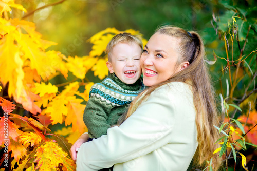 happy mother with her little son goulabt in autumn park at sunset