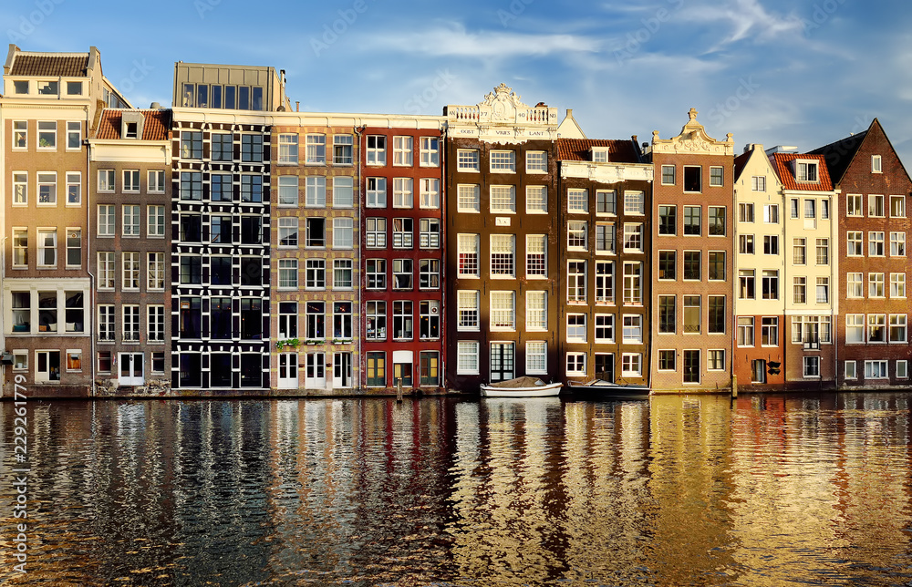 Famous dancing houses of the Damrak canal in Amsterdam on sunset