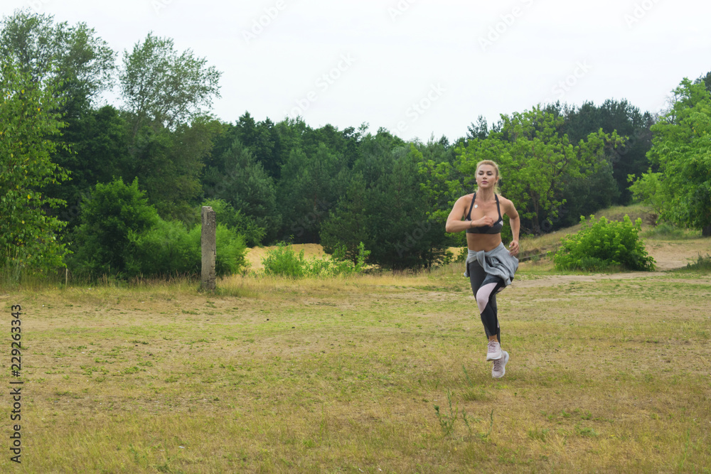 Woman running in green park on summer day Woman running in green park on summer day