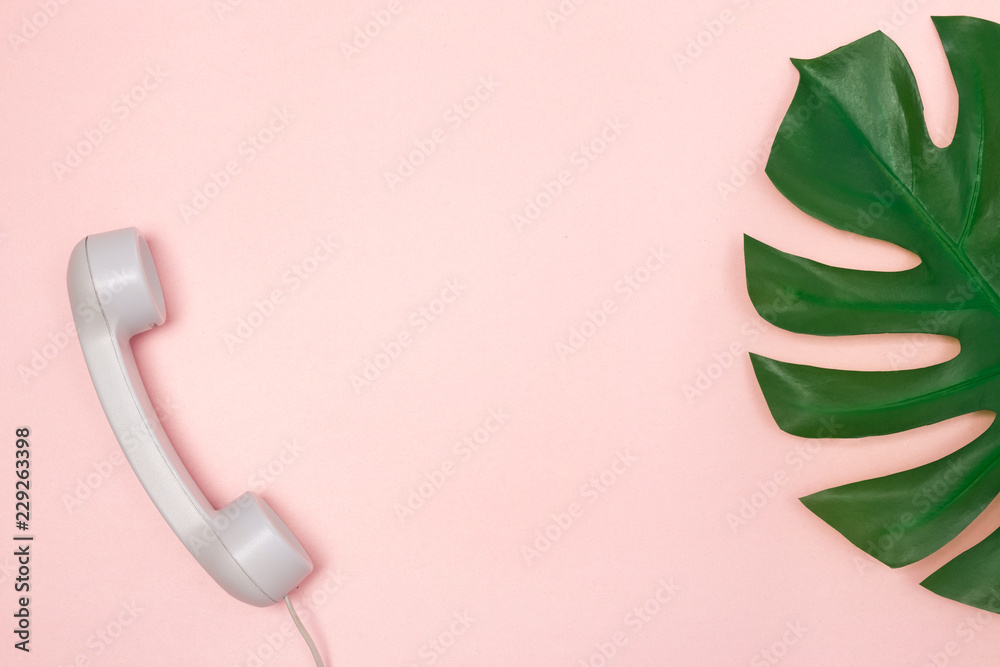 Phone receiver and Monstera palm leaf on pink background - obrazy, fototapety, plakaty 
