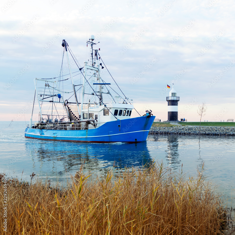 Krabbenkutter zurück im Heimathafen Wremen mit Leuchtturm, Nordseeküste bei Bremerhaven