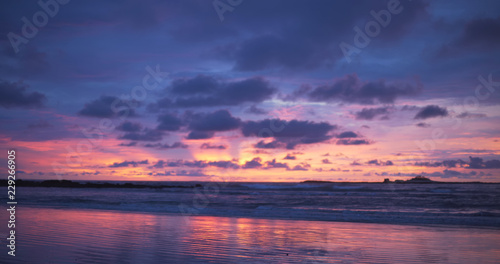 Out of focus background plate of orange, purple and blue sunset on the beach © rocketclips