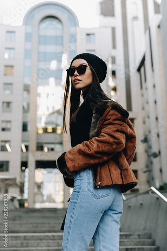 City style. Autumn/spring. Woman portrait. Stylish girl in casual clothes and sun glasses, outdoors