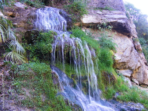 Close shot of the waterfall with the river and natural setting on the back
