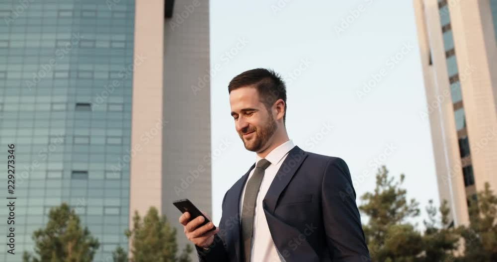 Confident multiethnic in suit and tie businessman texting on his smartphone via internet in the street - closeup 4k Confident multiethnic in suit and tie businessman texting on his smartphone via internet in the street - closeup 4k