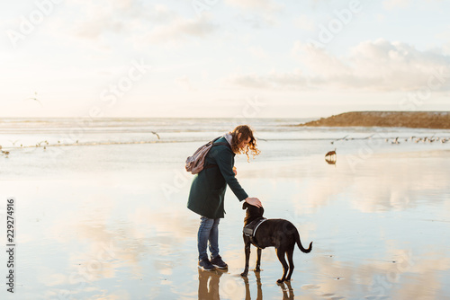 woman petting a dog at the beach