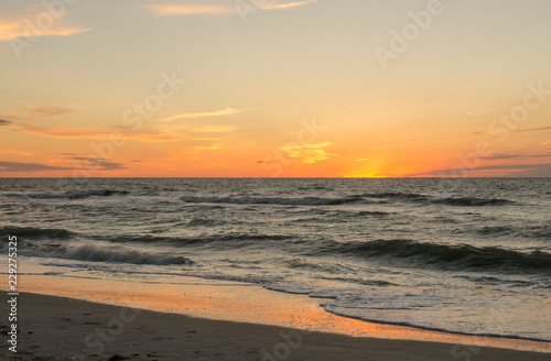 Sunset or sunrise over the ocean with orange and yellow tones © Kimberley W Hinson