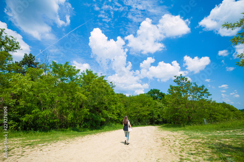 Girl walking on country road, near a forest