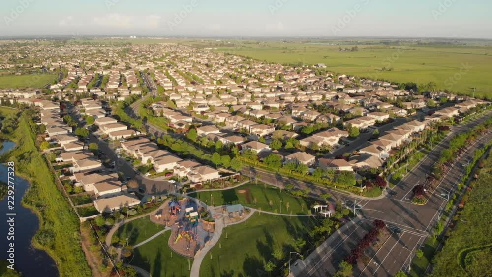 AERIAL: Flying over the asphalt roads running past luxurious suburban homes at scenic sunrise. Picturesque view of the modern suburban neighborhood near San Francisco on a beautiful autumn evening. AERIAL: Flying over the asphalt roads running past luxurious suburban homes at scenic sunrise. Picturesque view of the modern suburban neighborhood near San Francisco on a beautiful autumn evening.