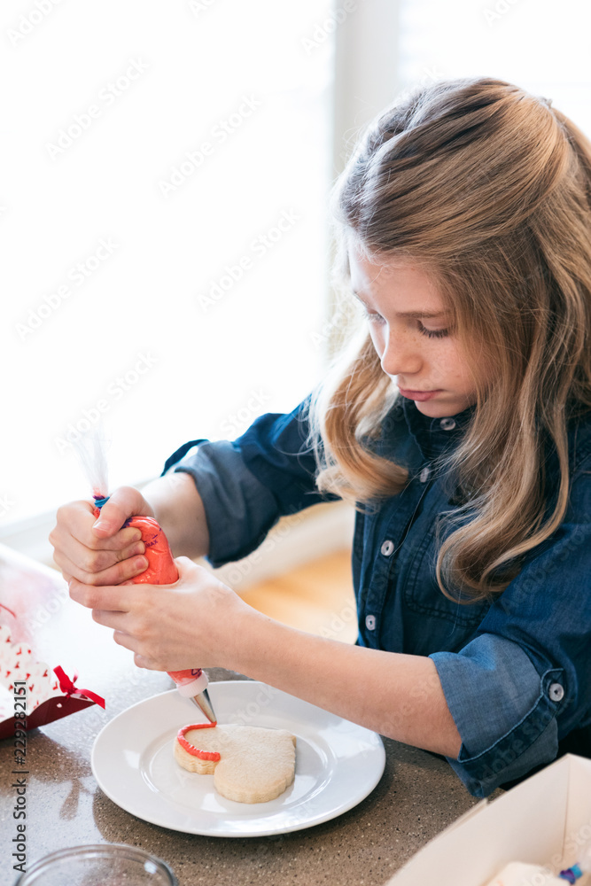 Valentine: Girl Squeezing Buttercream Frosting Onto Cookie Valentine: Girl Squeezing Buttercream Frosting Onto Cookie