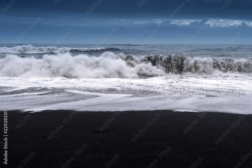 Black sand beach and ocean waves in Iceland.