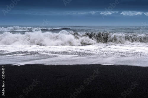 Black sand beach and ocean waves in Iceland.