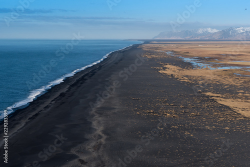 Looking west from Dyrholaey at the vast volcanic black sand beach with mountains in the background