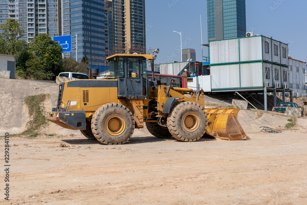industrial building construction site mini bulldozer levelling and moving soil during highway building