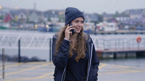 Happy girl talks to her friend on the phone