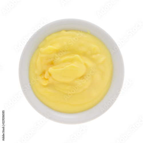 Top view of homemade banana cream pudding in a small bowl isolated on a white background.