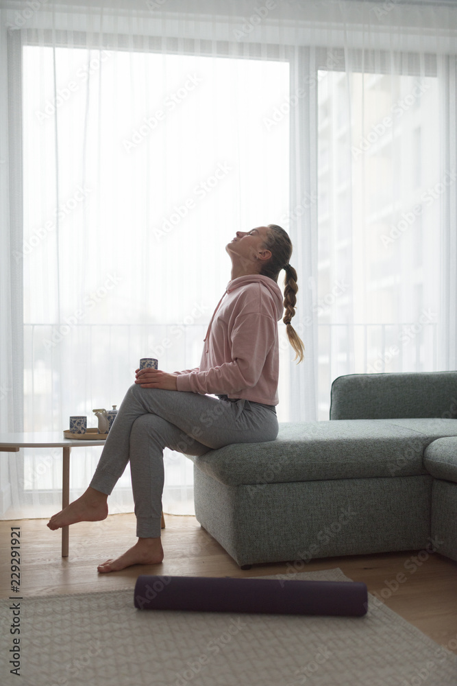 Woman enjoying a cup of tea in the living room Woman enjoying a cup of tea in the living room