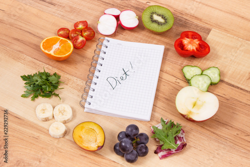 Word diet in notepad and fresh ripe fruits and vegetables as healthy eating containing vitamins