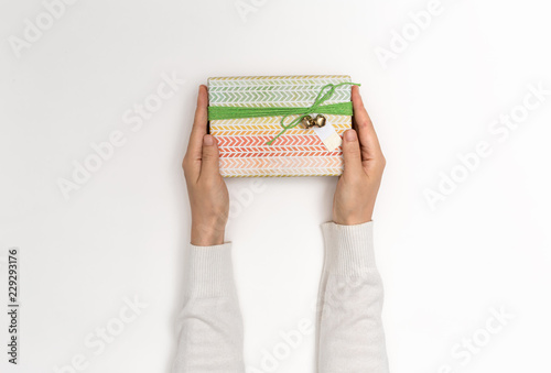 Person holding a Christmas gift box on a white background