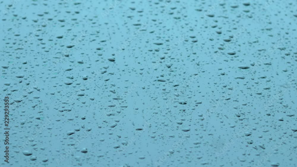 The rain falls on the glass and flows downwards. Abstract background and texture of raindrop. Select focus shallow depth of field. The rain falls on the glass and flows downwards. Abstract background and texture of raindrop. Select focus shallow depth of field.