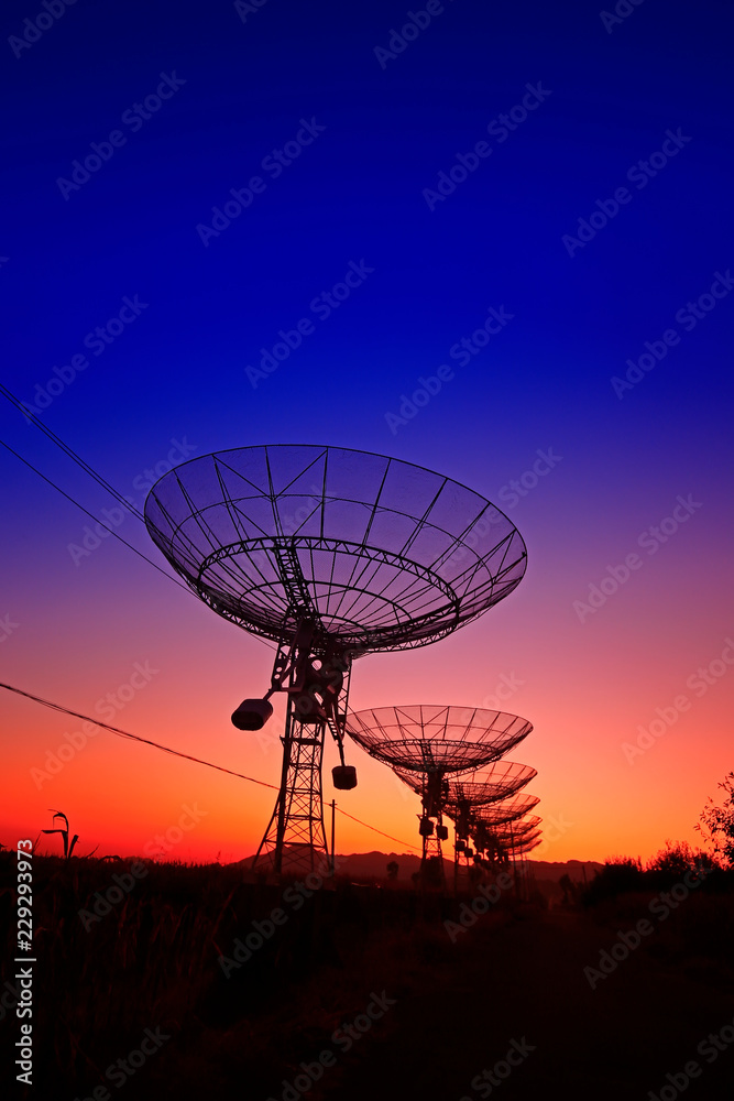 The silhouette of a radio telescope observatory