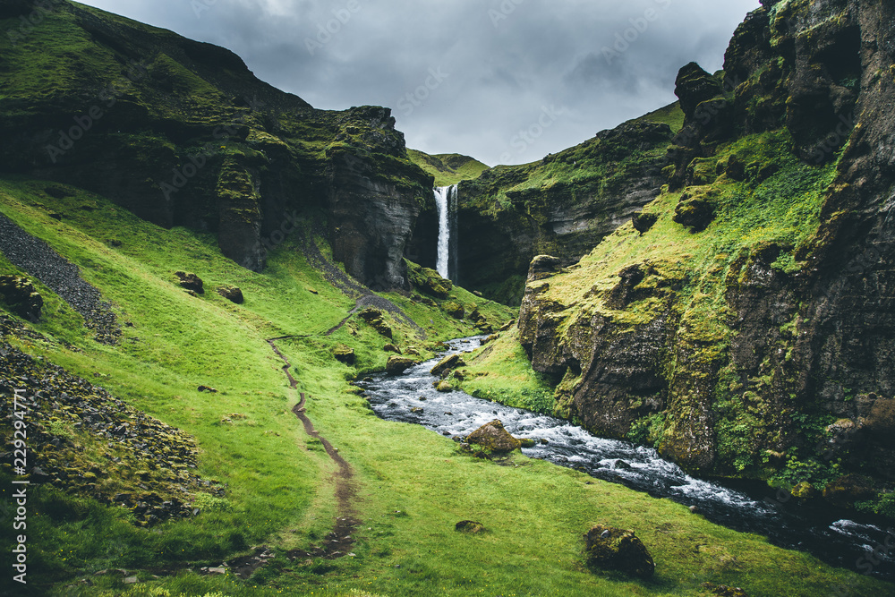 Fotografie Waterfall in rugged Iceland valley - Kvernufoss