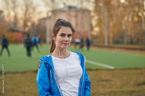 Fototapeta Naklejka Na Ścianę i Meble -  Beautiful girl listens to a player at the stadium.
