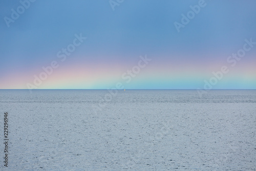 Rainbow over ocean photo