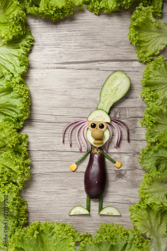 Funny cook made with vegetables on wooden board