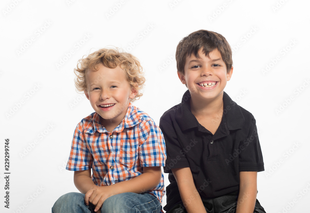 Cute, laughing, little boys sitting together, isolated on white background Cute, laughing, little boys sitting together, isolated on white background