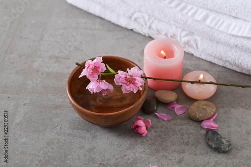 cherry blossom sakura with wooden bowl ,towel, candle, stones on gray background