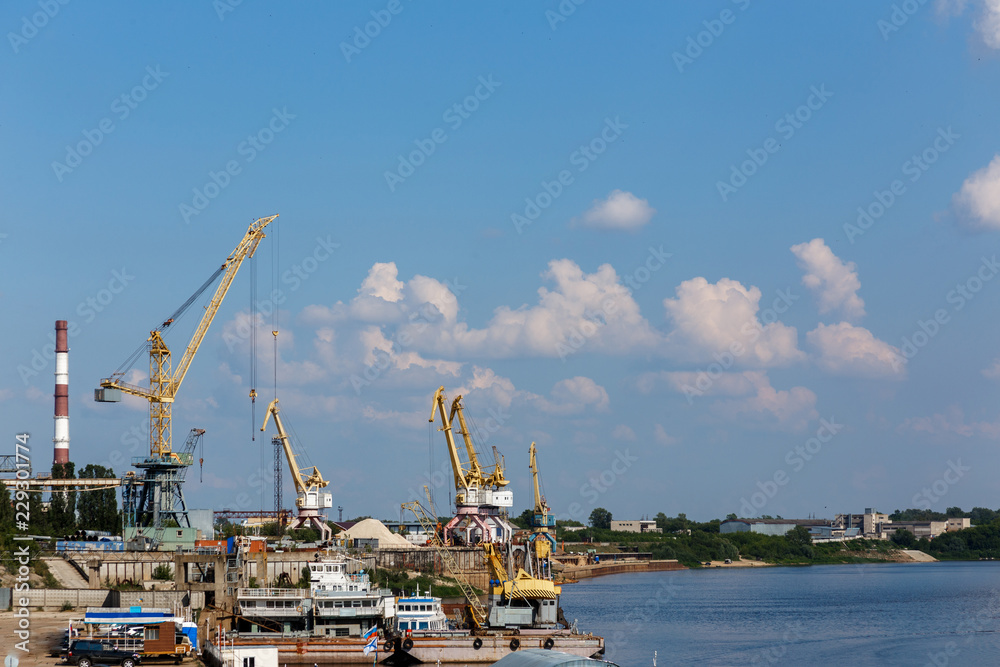 Yellow harbor cranes near power station