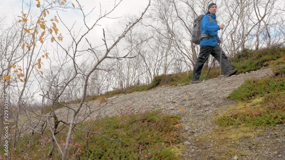 The traveler goes alone with a backpack, in a mountain hike. View from the bottom He leads a healthy lifestyle. The traveler goes alone with a backpack, in a mountain hike. View from the bottom He leads a healthy lifestyle.