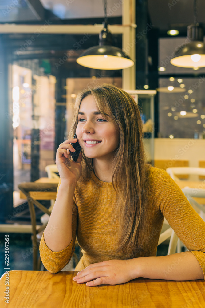 Casual businesswoman in coffee shop and talking on phone Casual businesswoman in coffee shop and talking on phone