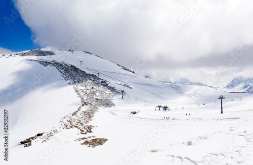cable car along the mountain slope covered with snow, Caucasus mountains, ski resort