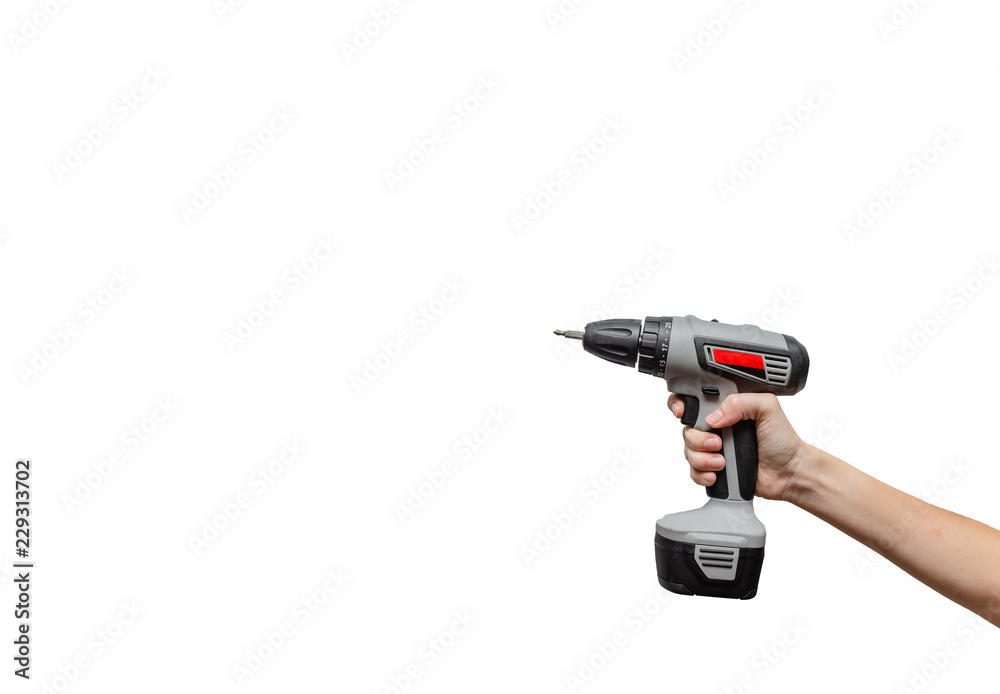 Female hands holding a drill . Concept. European Young woman is using an electric drill Female hands holding a drill . Concept. European Young woman is using an electric drill