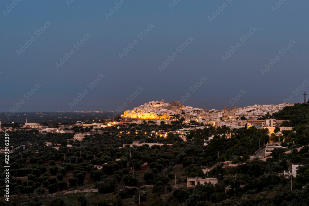 Panoramic view of the medieval white village of Ostuni at sunset blue hour