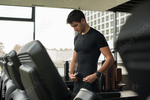 young man preparing to run on treadmill